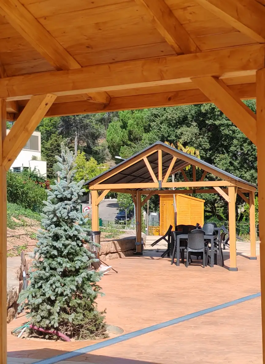 Espacio cubierto para actividades y talleres en el jardín terapéutico de una residencia de ancianos en Pallejà