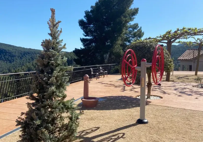 Zona de ejercicio al aire libre con aparatos y vistas a la montaña en la residencia Sol i Natura